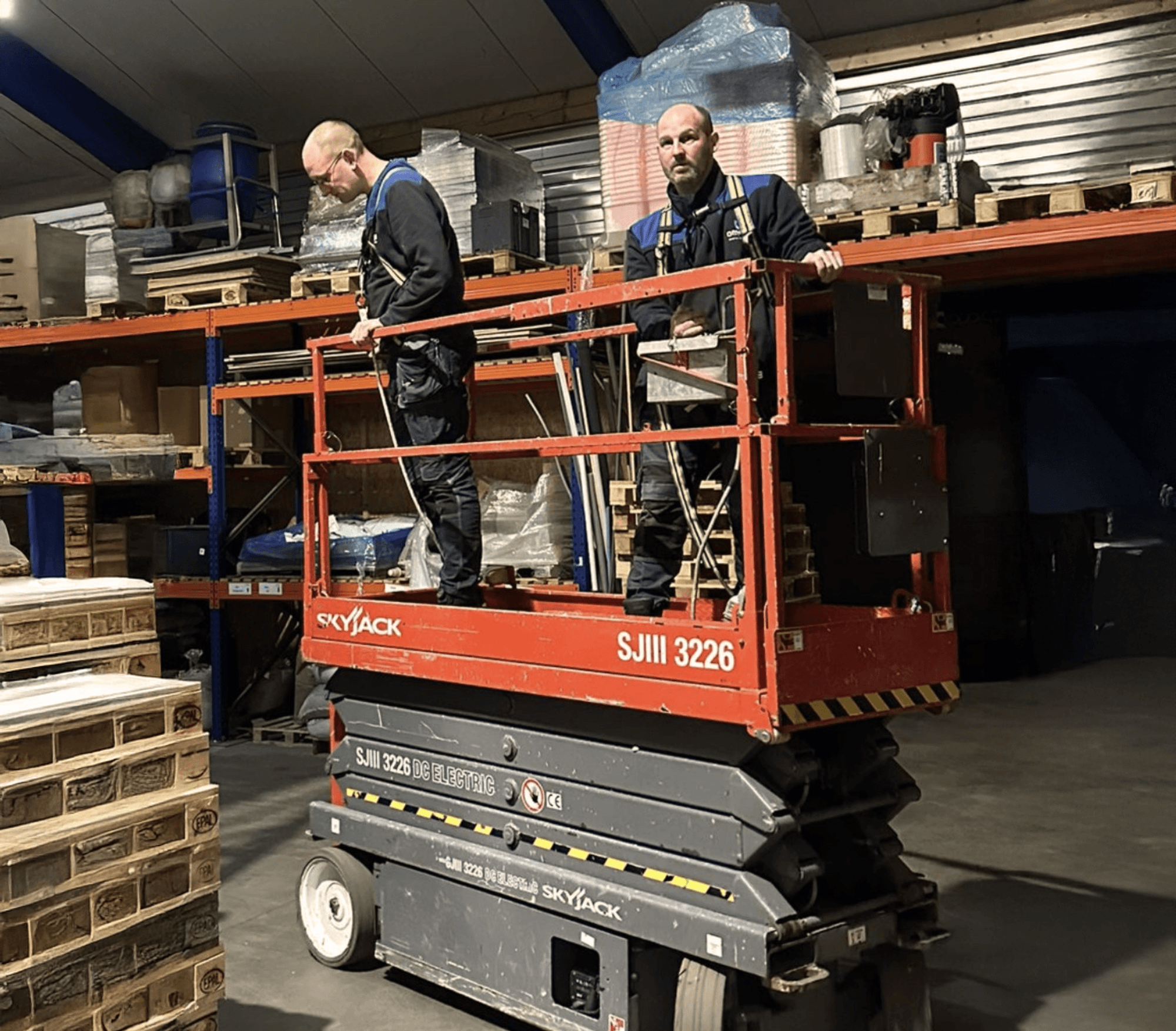 Een kind zit op een bank en aait zachtjes een zwarte hond in een met zonlicht gevulde kamer.