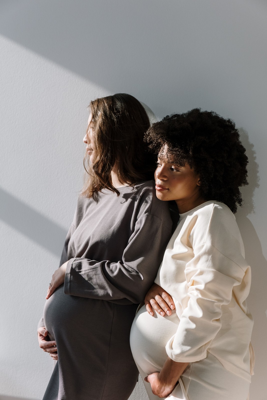 Two women sitting close together in a quiet, supportive moment.