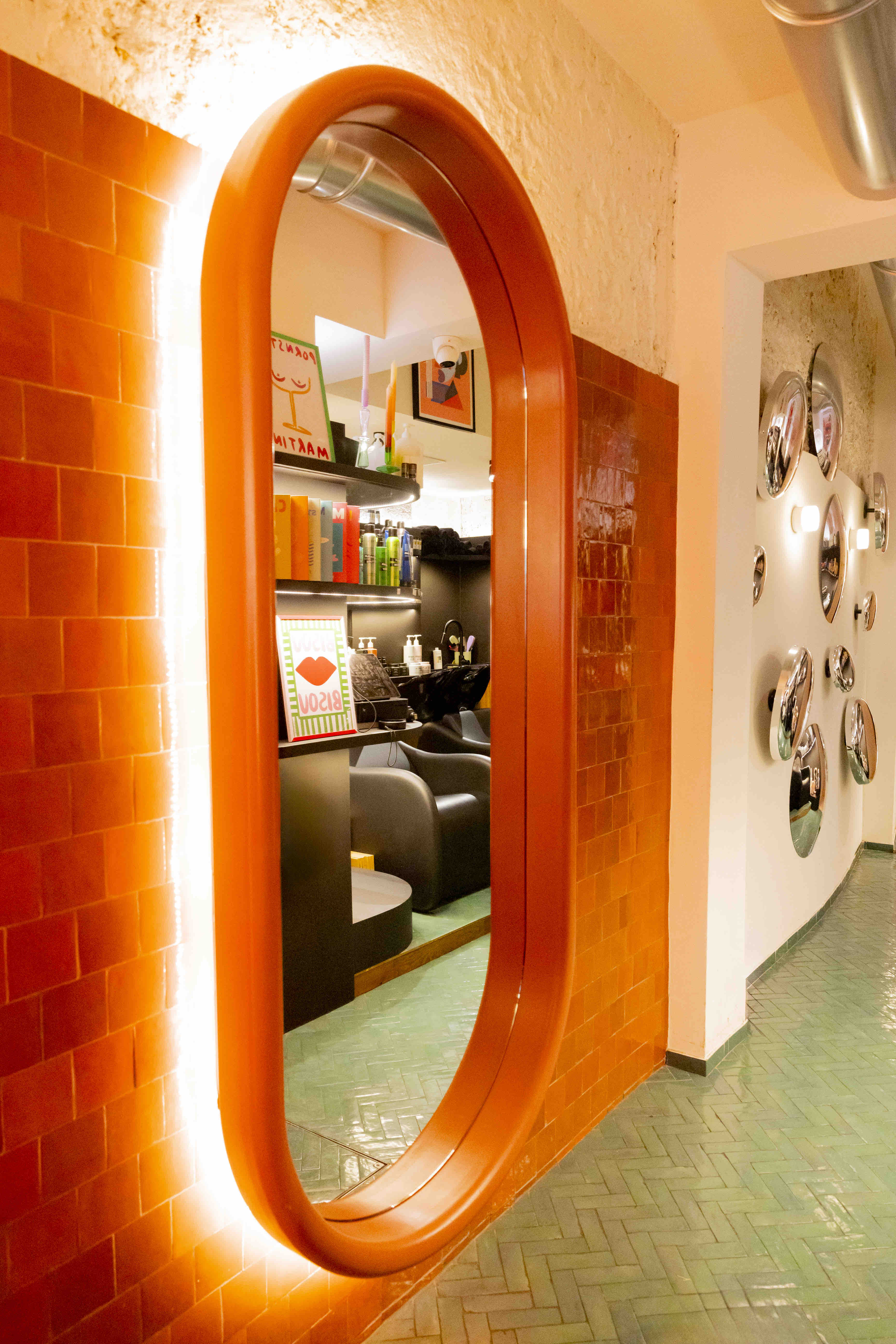 Entrée design aux briques oranges d'un salon de coiffure ECLA Group à Paris