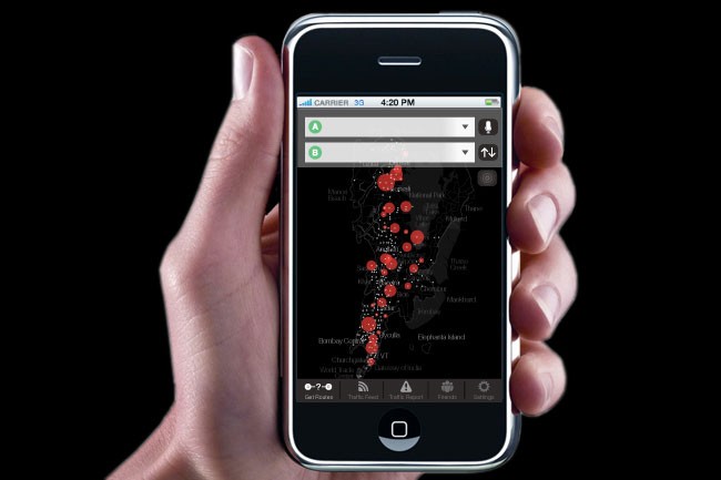 A hand holds a black iPhone displaying a map application. The map shows red dots clustered in the central area, with labels including “A” and “B” at the top. Below the map are icons for “Carrier 33,” “4:20 PM,” “A,” “B,” “Down,” and “Apple.” The bottom of the screen shows standard iPhone navigation buttons. The background is solid black.