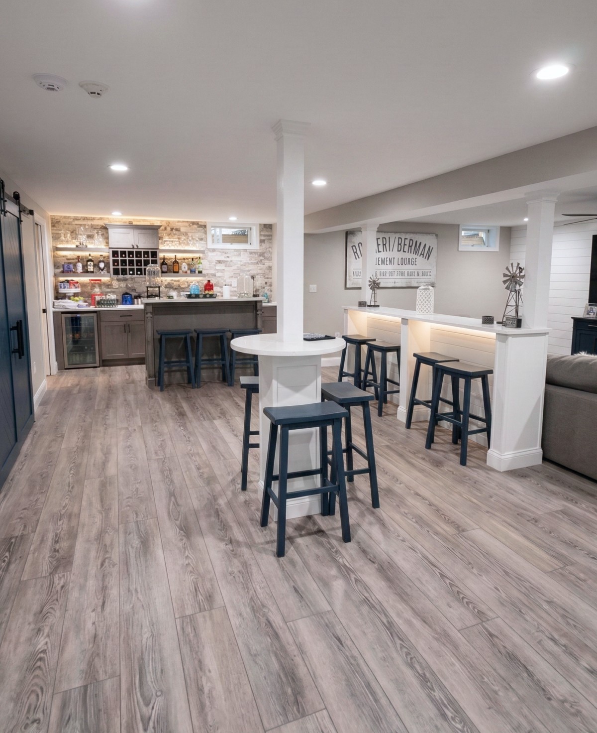 Finished basement renovation with custom bar, seating area, and built-in cabinetry