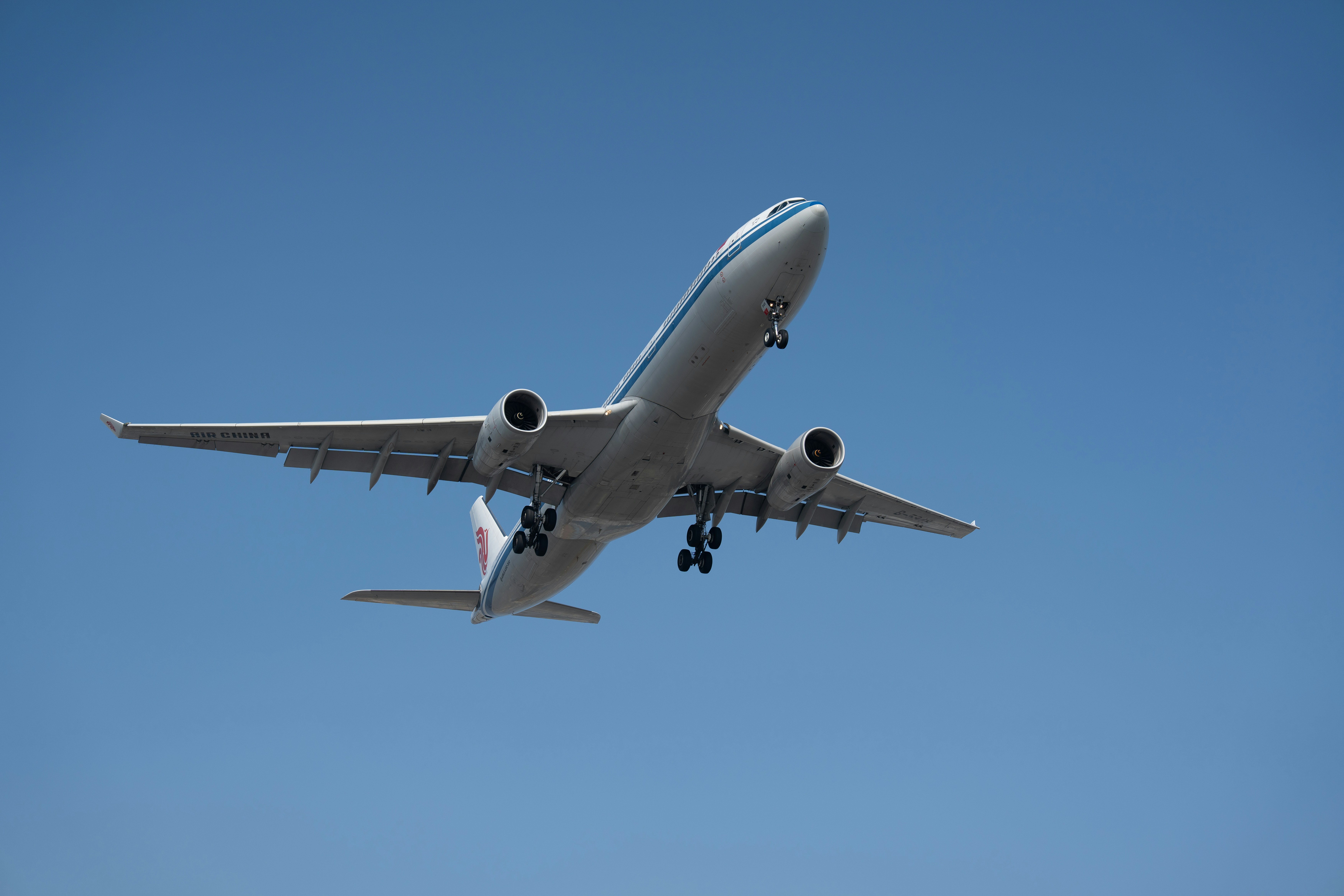 Airplane ascending into a clear blue sky.