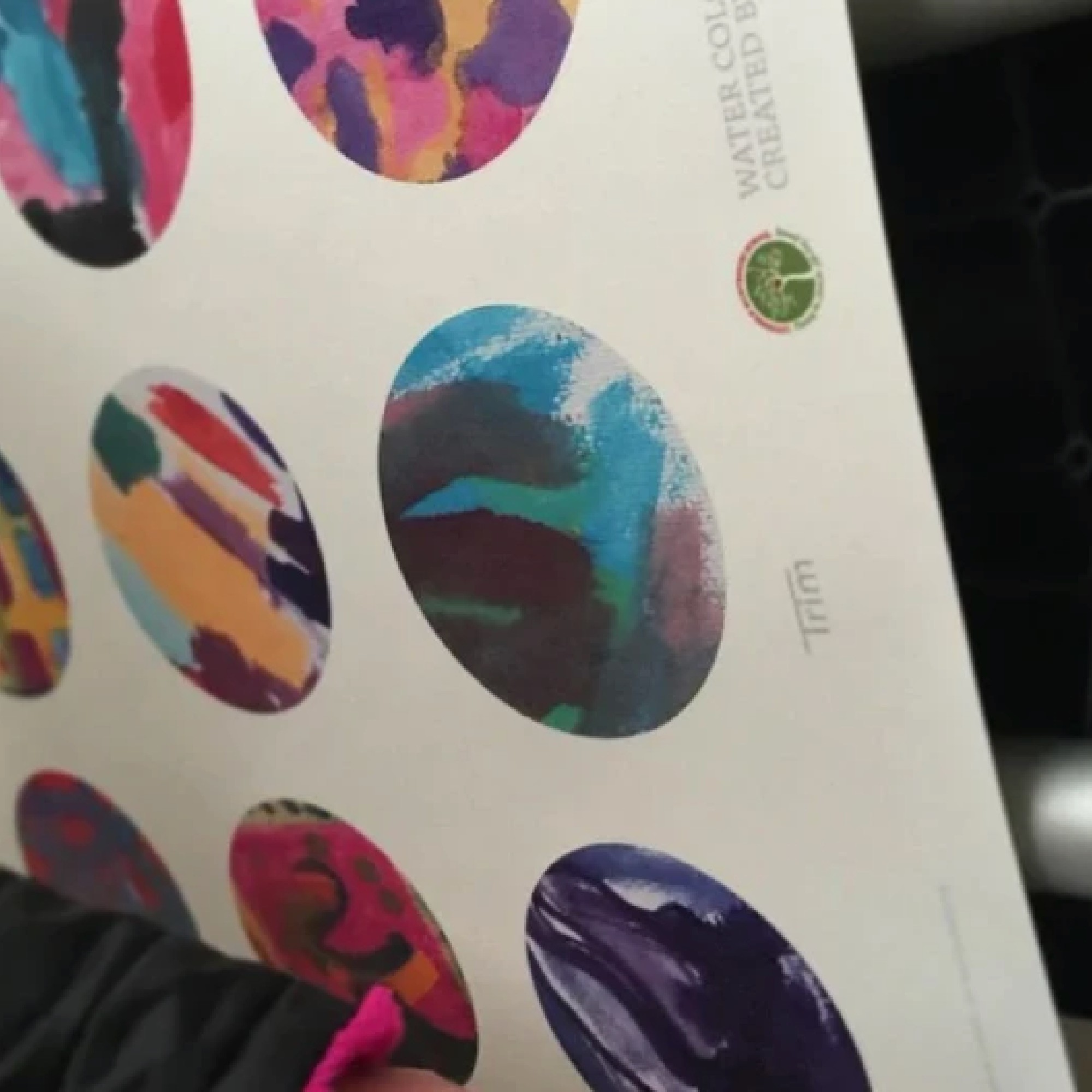 Child pointing at wallpaper coming off a large printer.