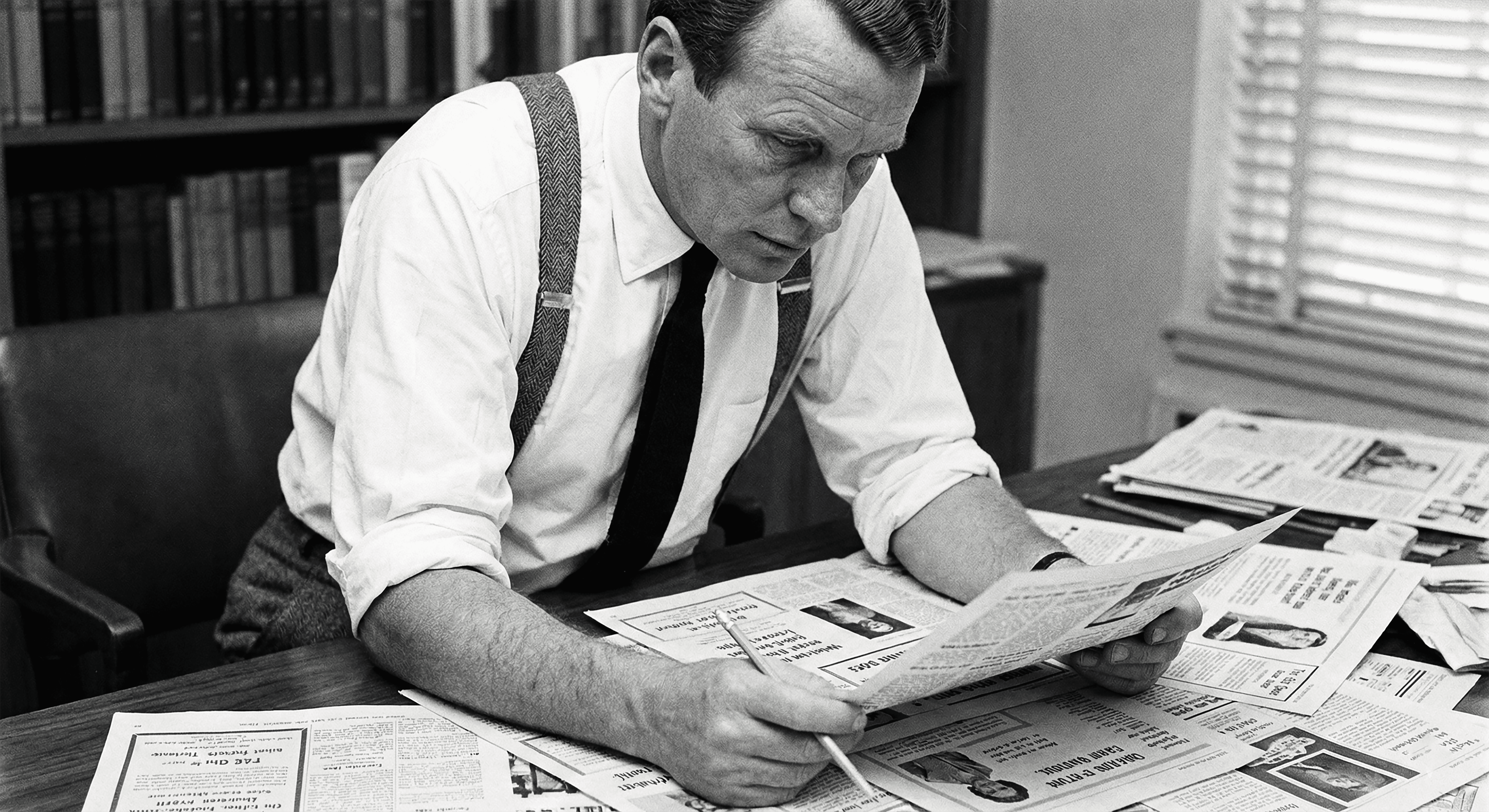 David Ogilvy on advertising, working at his desk and reviewing ad proofs in the 1960s.