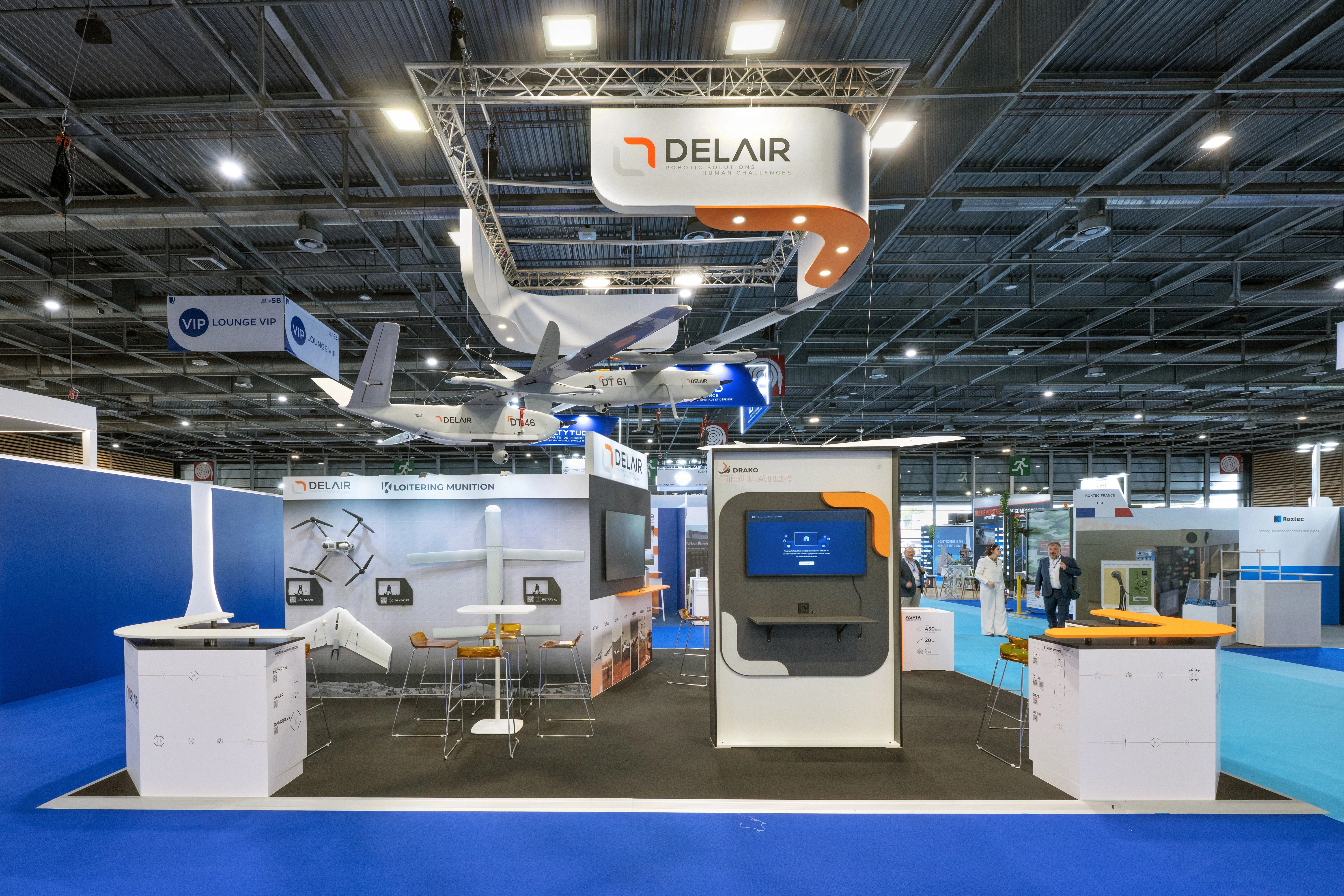 Stand Delair conçu et réalisé par Expace à Eurosatory 2026 – espace sur-mesure défense avec drones à voilure fixe suspendus, enseigne lumineuse, simulateur interactif et murs produits.
