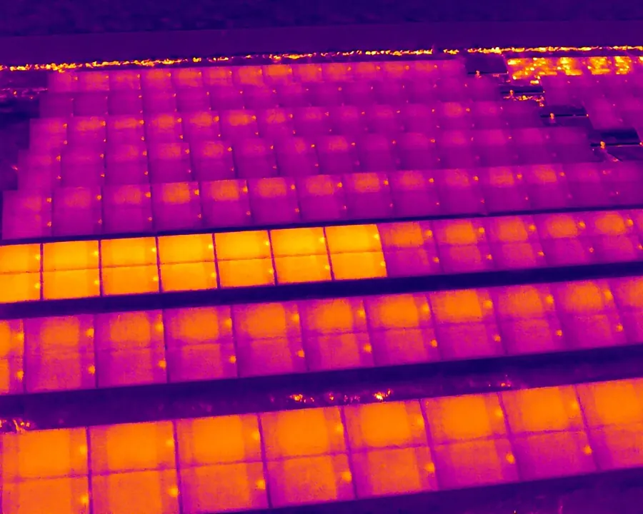 Thermal image: a row of panels running uniformly warmer than its neighbors