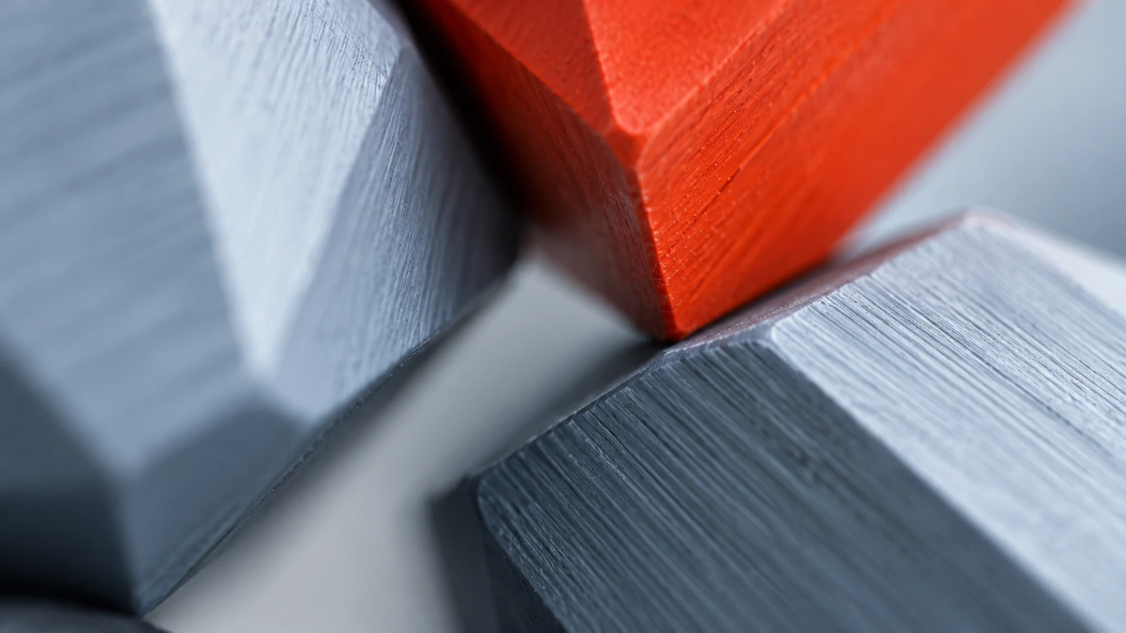 Faceted grey blocks with one orange block, close-up