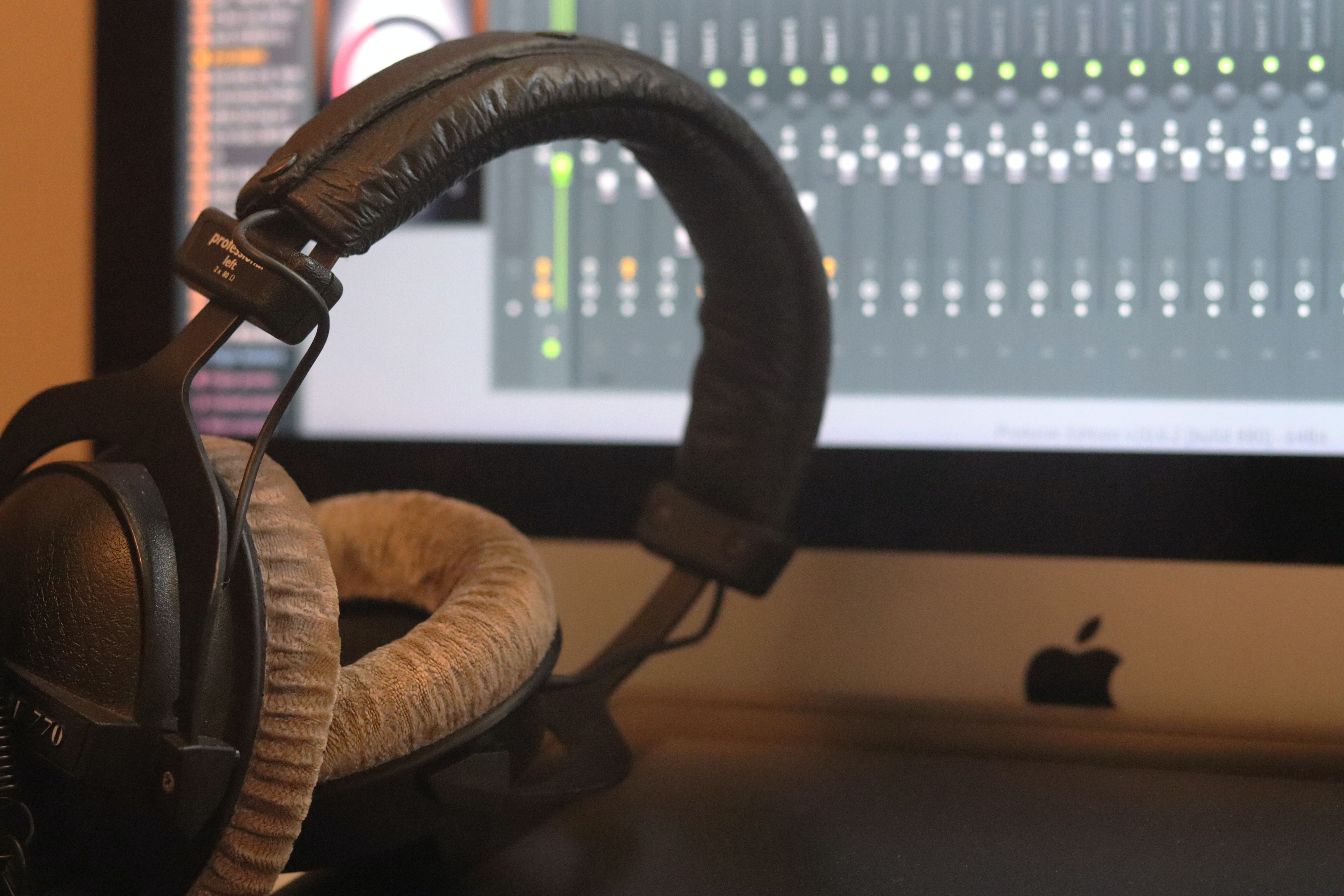 Headphones near a computer sound editing screen - Kits AI vs Musicfy 