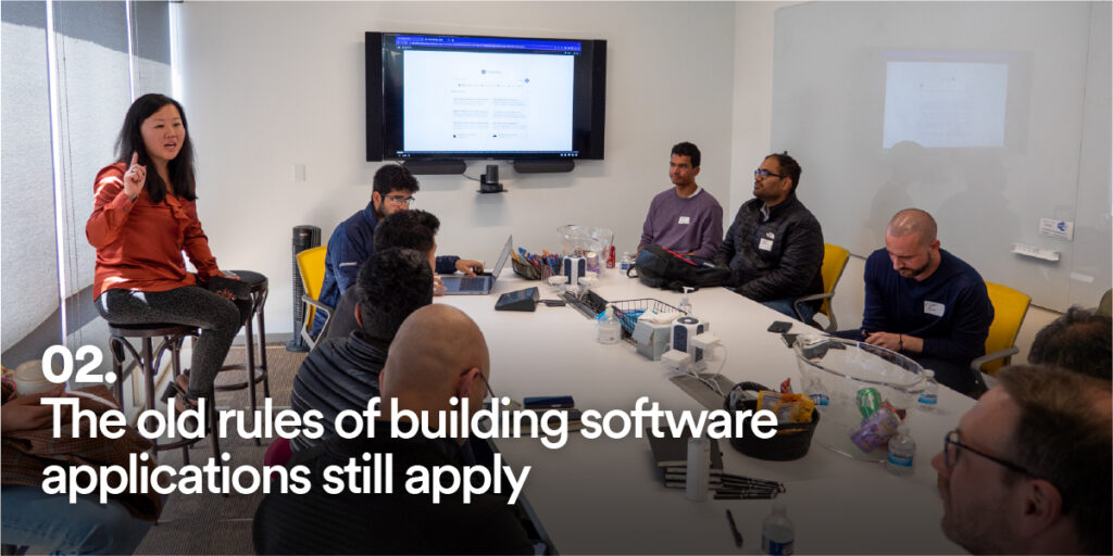 People at Generative AI Unconference with the text "The old rules of building software applications still apply"