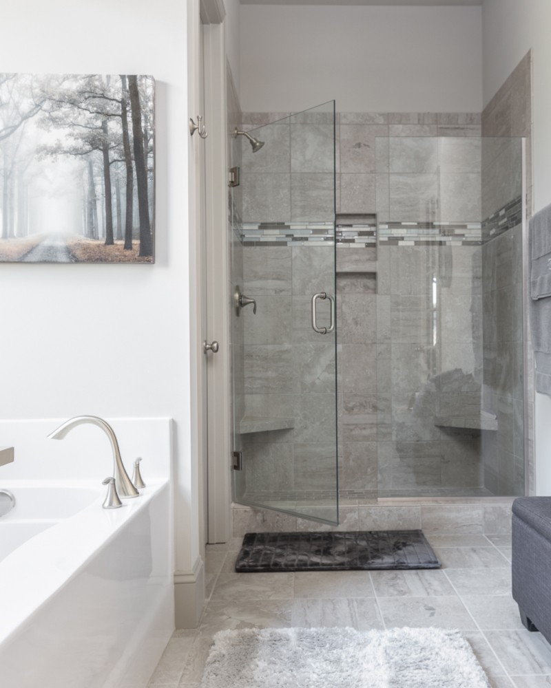 Smiling young man with short hair poses against a dark background, wearing a green button-up shirt.