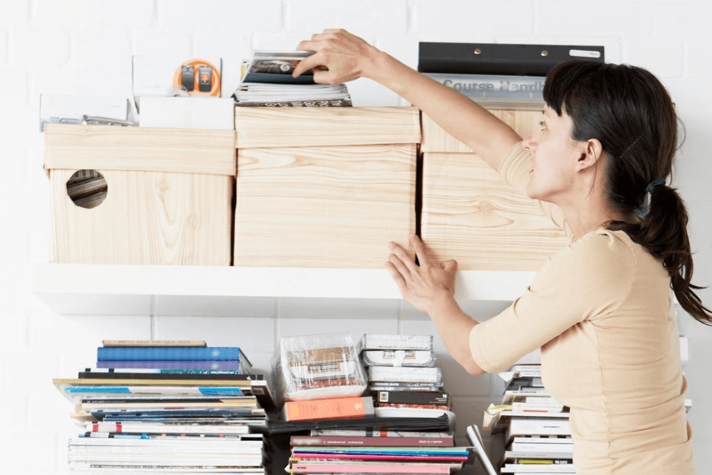 woman reaching for shelf in home office