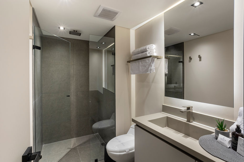 Habitación de lujo con cama king Medellín en Altus Hotel, con ventanales insonorizados y diseño elegante en Laureles.