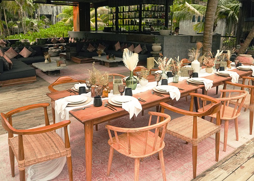Group of people discussing their spiritual yoga journey on the beach at Nomade Holbox in Tulum Mexico, with a serene and peaceful atmosphere
