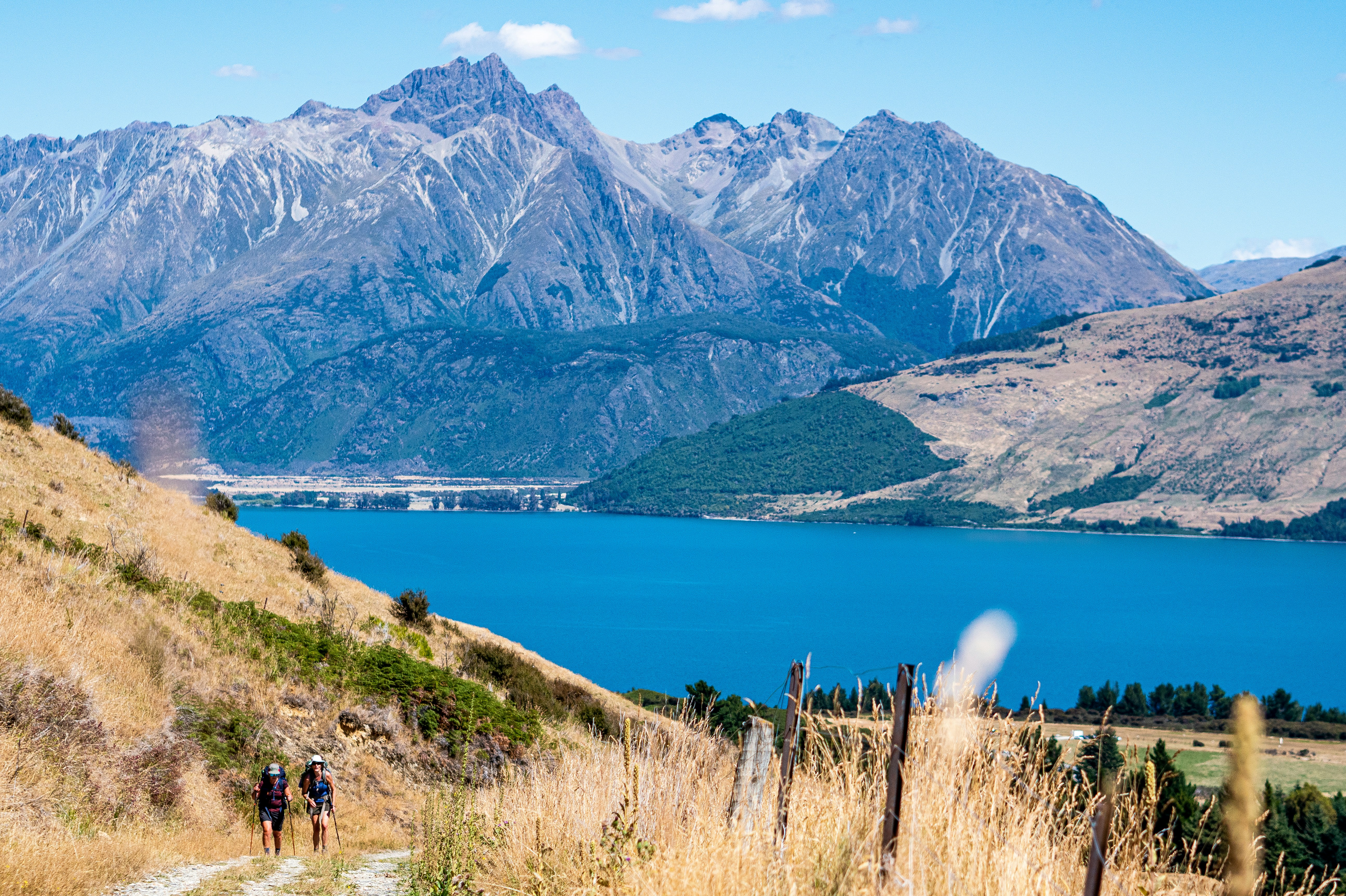 People walking through a vast mountain landscape near Lake Wakatipu at Glenorchy.