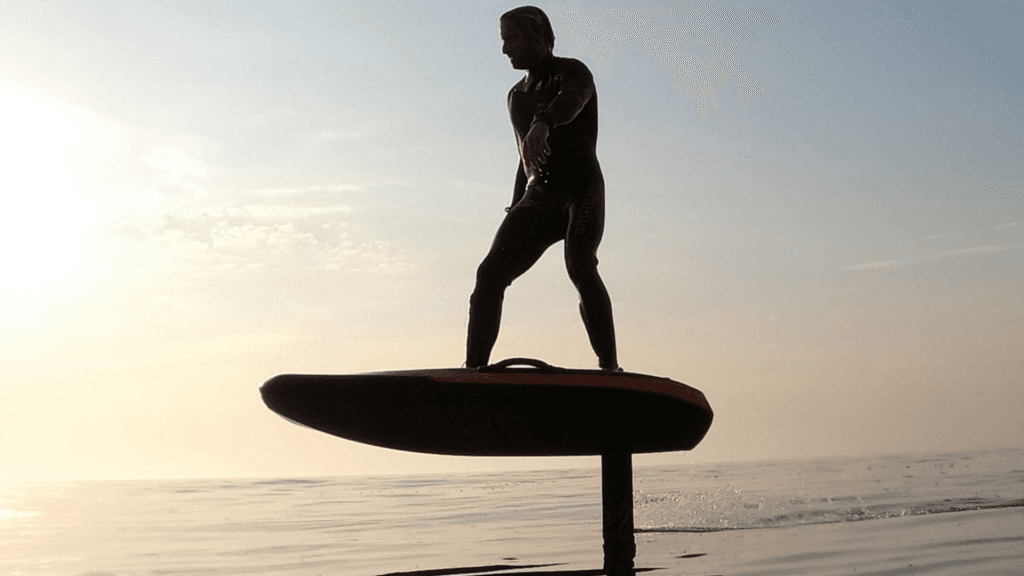 A man stading with Surfboard