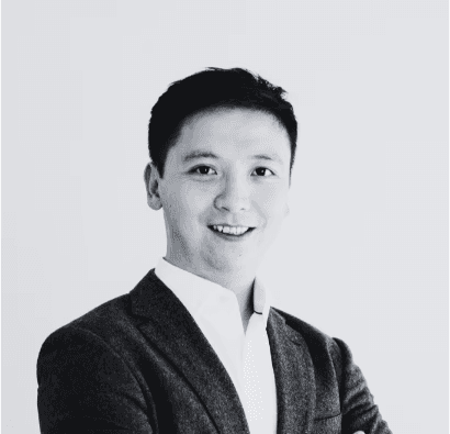 black and white photo of the upper part of a asian man in a suit with white shirt and his arms crossed. this is the COO of BeyondTrucks, Paul Xie