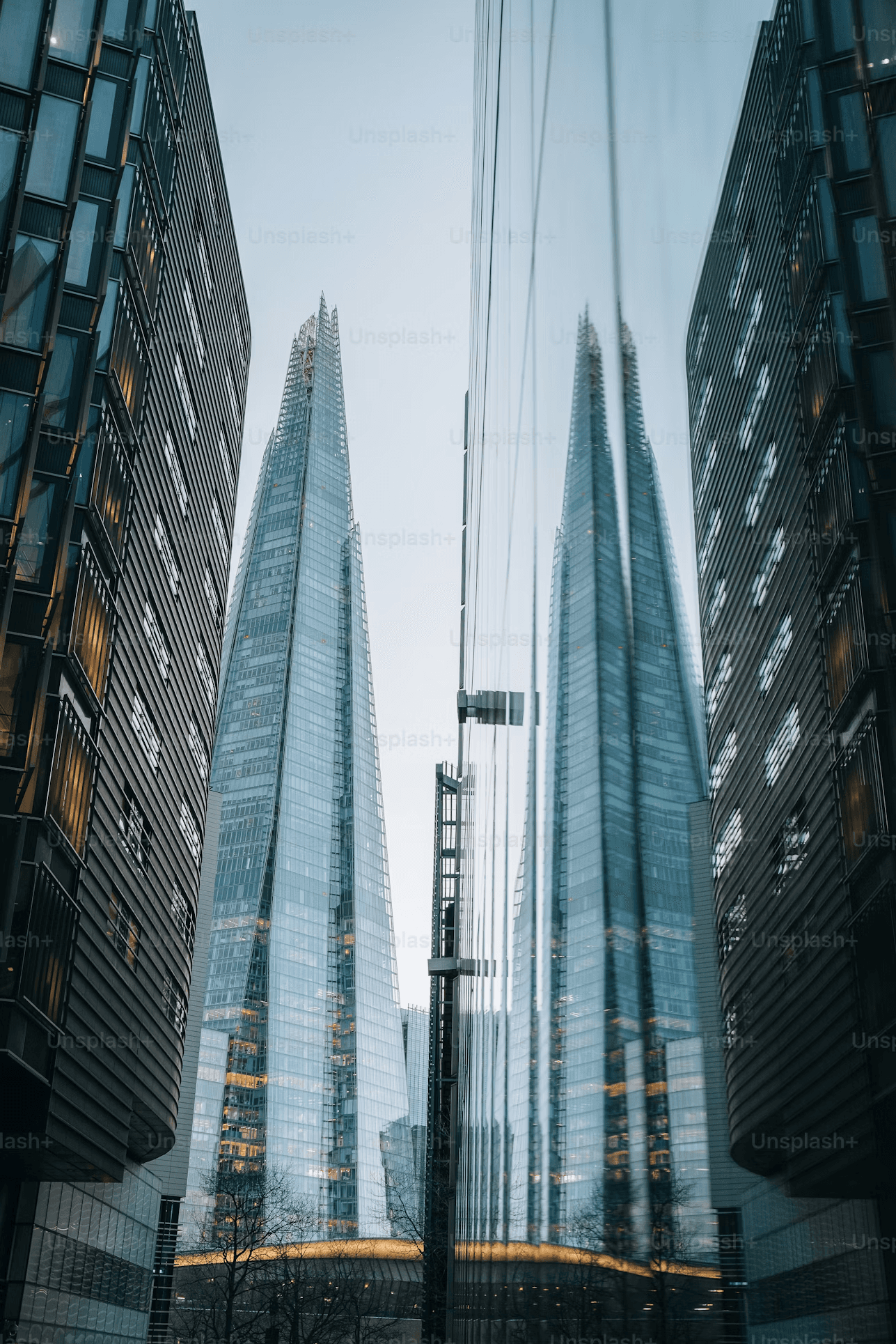 Clear skincare bottle with pink cap, bi-phase serum and floating bubbles on a white backlit background.