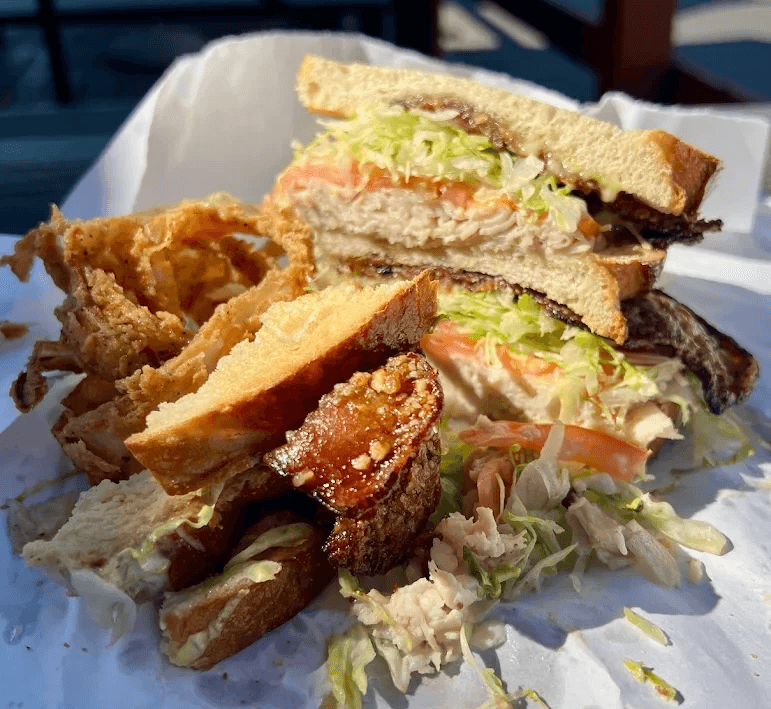 Healthy sandwich choice with lettuce and tomato from Big Jims Roast Beef with a side of onion rings in San Diego.