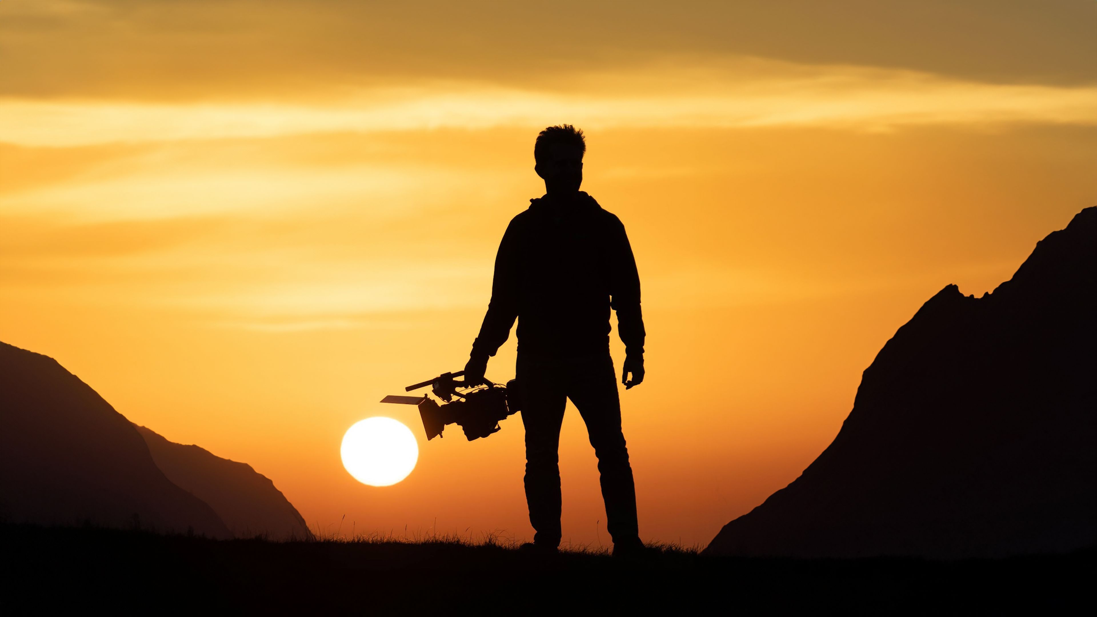 A close-up of a person wearing green-tinted glasses, with a serious expression and smooth skin.