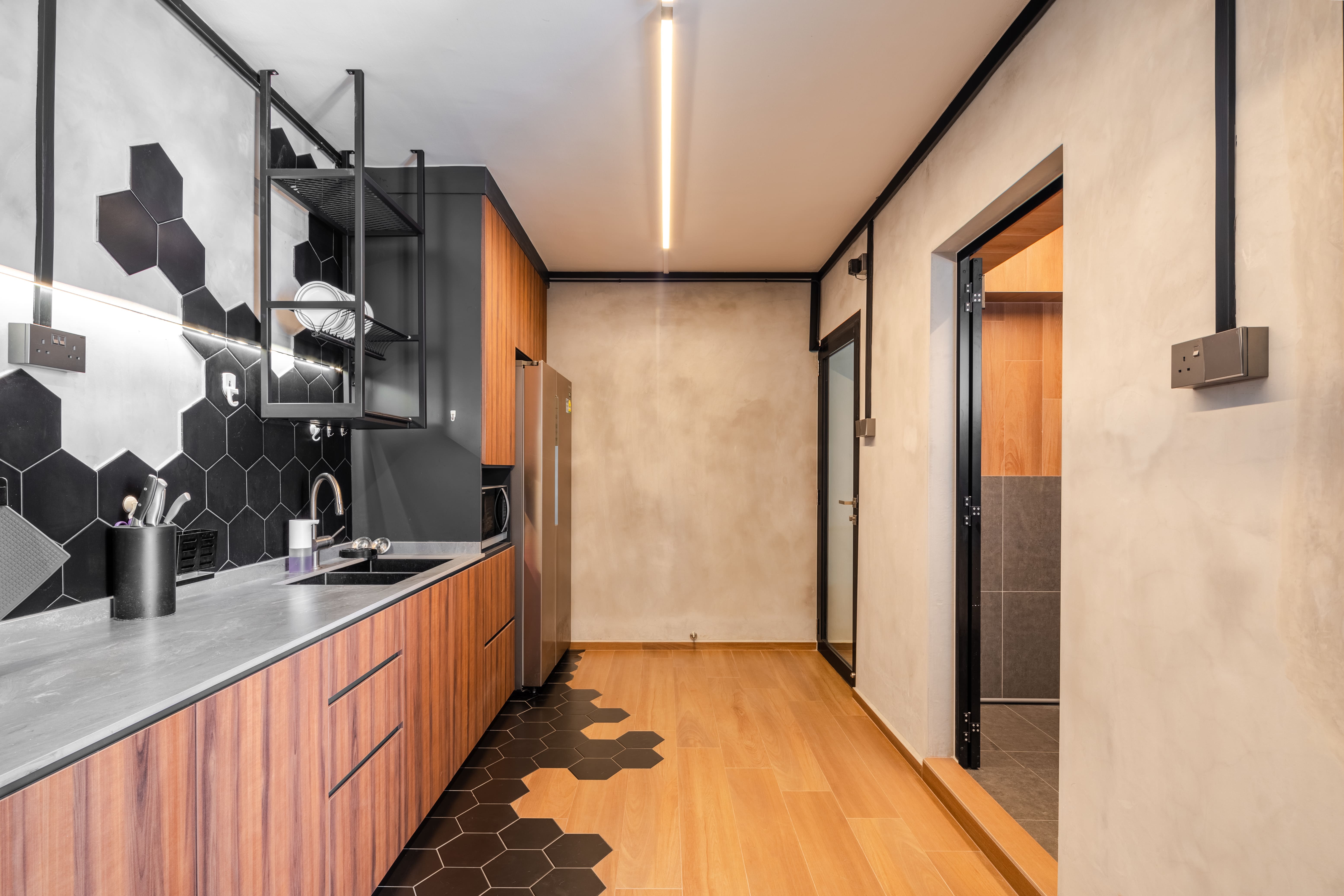 Kitchen walkway featuring a creative floor transition from wood to hexagonal tiles, enhancing visual flow and zoning.