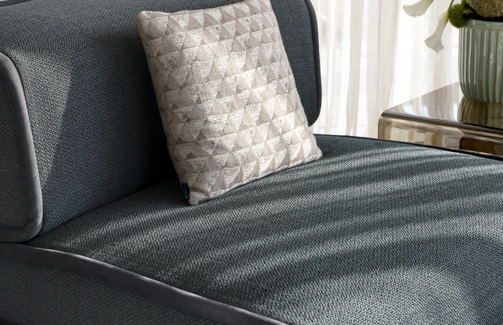 lateral view of an artistic soft armchair with waves and contrasting piping