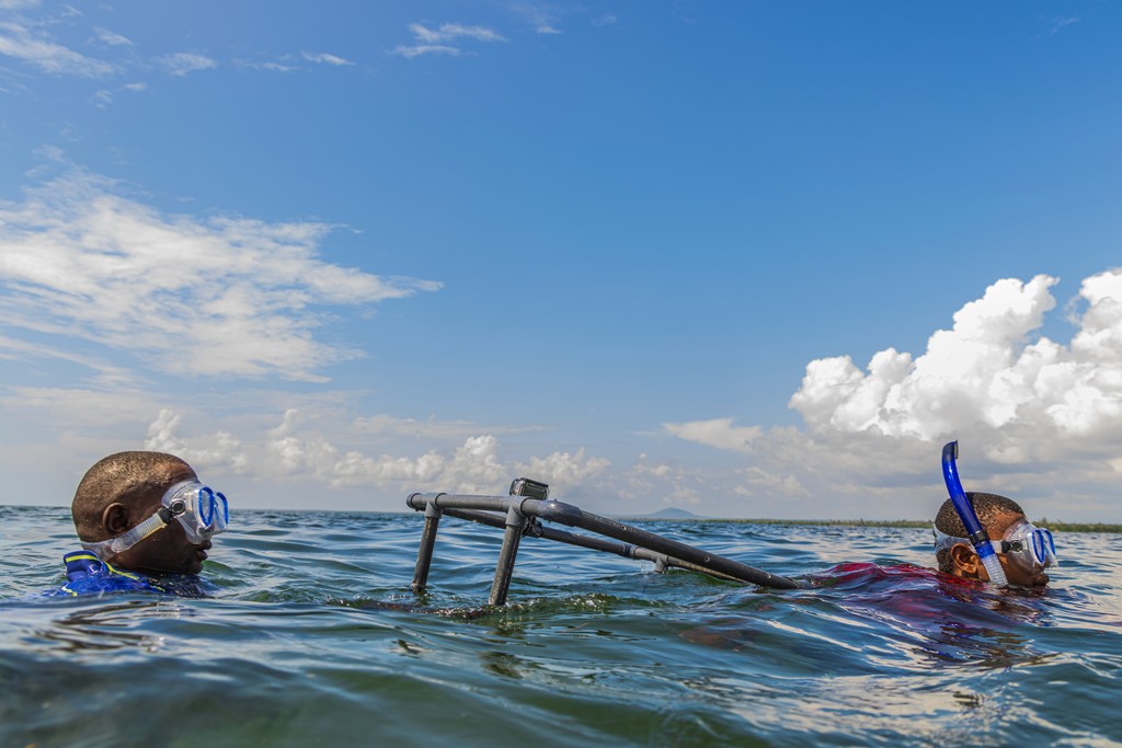 Two men holding a remote underwater video stand in water  (c) Anthony Ochieng Onyango