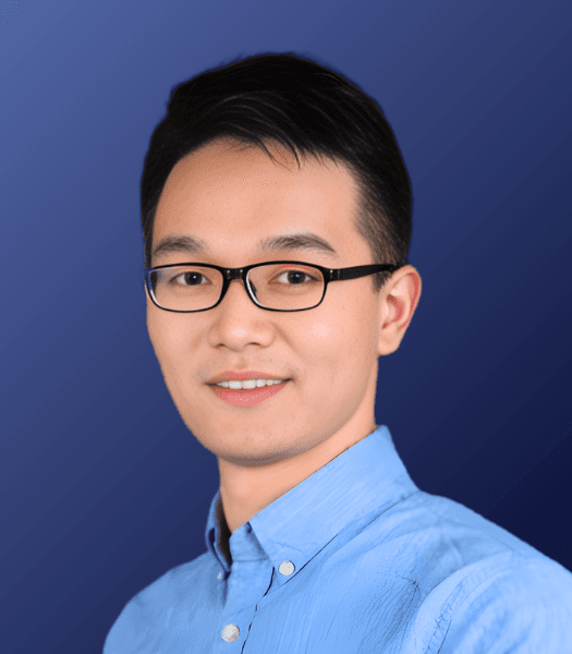 Professional headshot of Anytime AI co-founder Hugo Chen wearing blue button-up shirt and glasses smiling slightly at camera.
