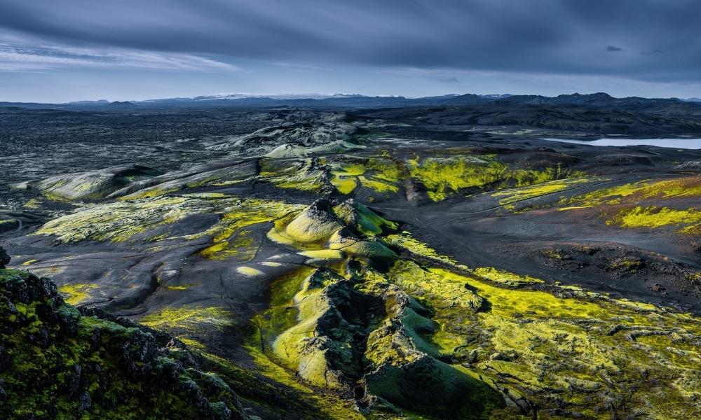 Panoramic view of the Lakagígar crater row in Iceland, featuring moss-covered volcanic cones, dark lava fields, and rugged fissure terrain created during the historic Laki eruption.