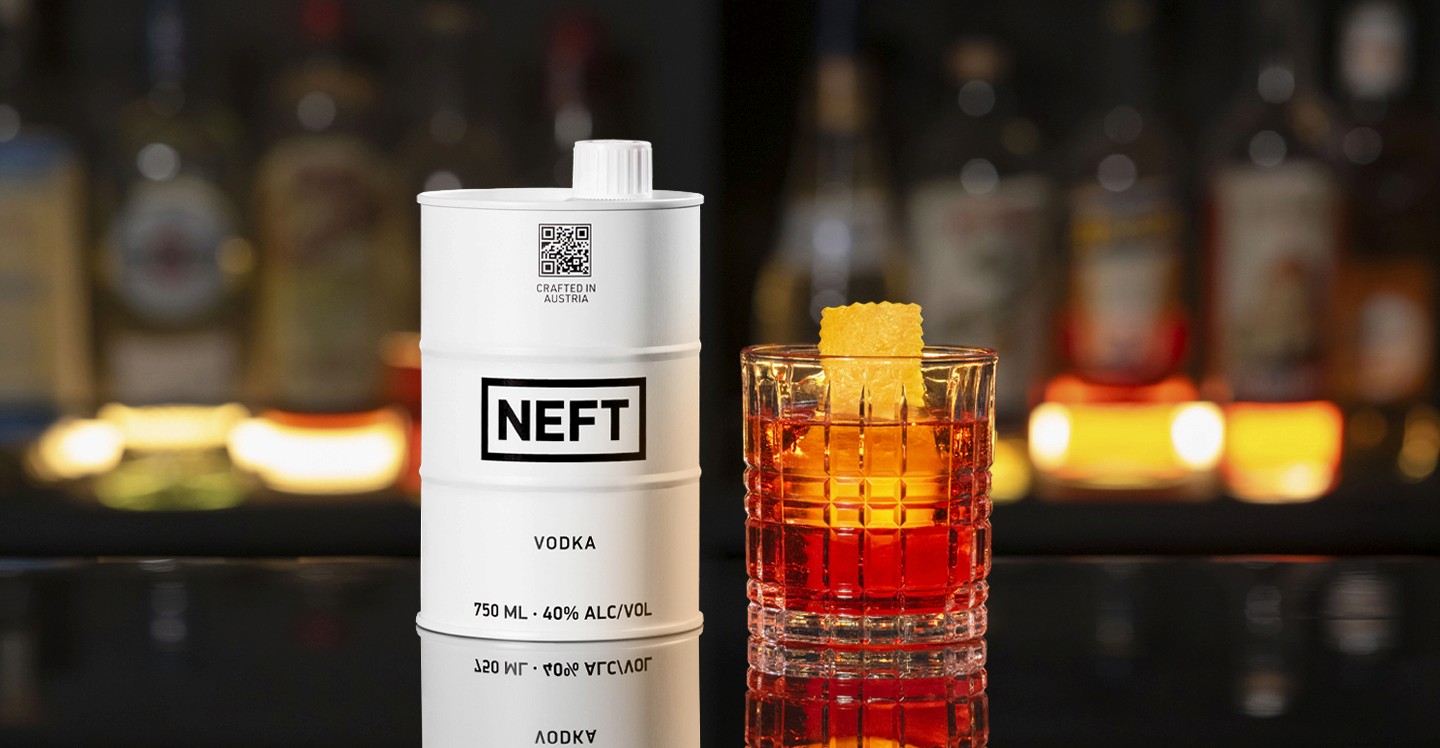 A NEFT Barrel and a glass of Traditional Negroni on a bar counter.