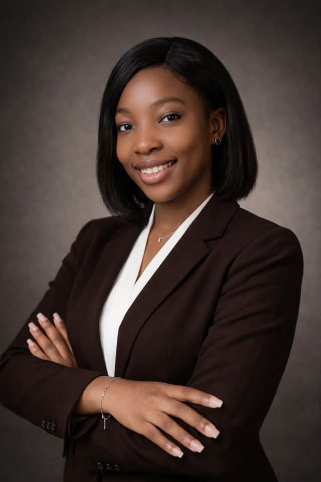 A woman with red hair is standing in the grass