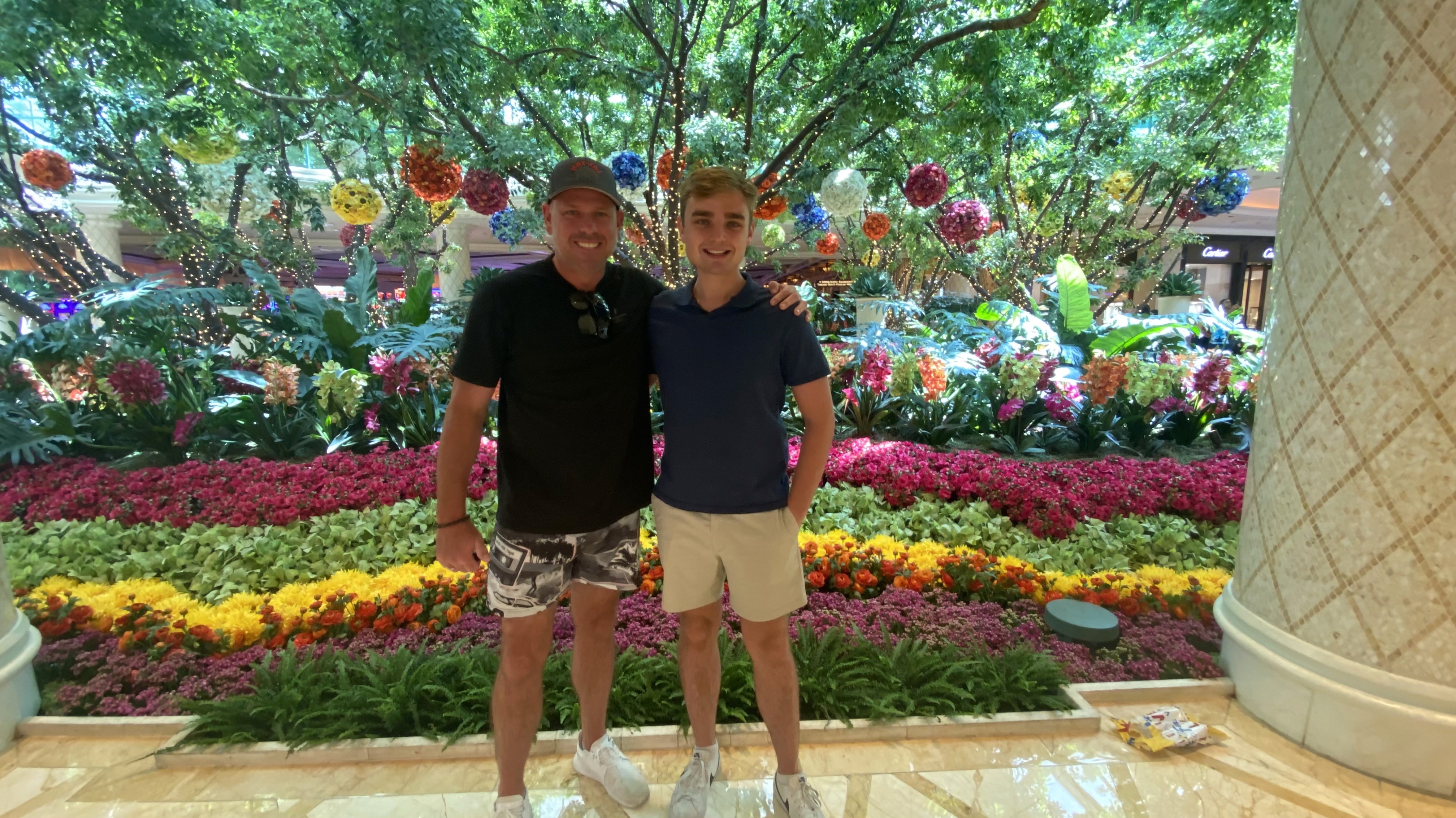 MoFlo founders, the Nathan, CEO (left) and Tristan, CTO (right), standing together in front of a vibrant flower display.