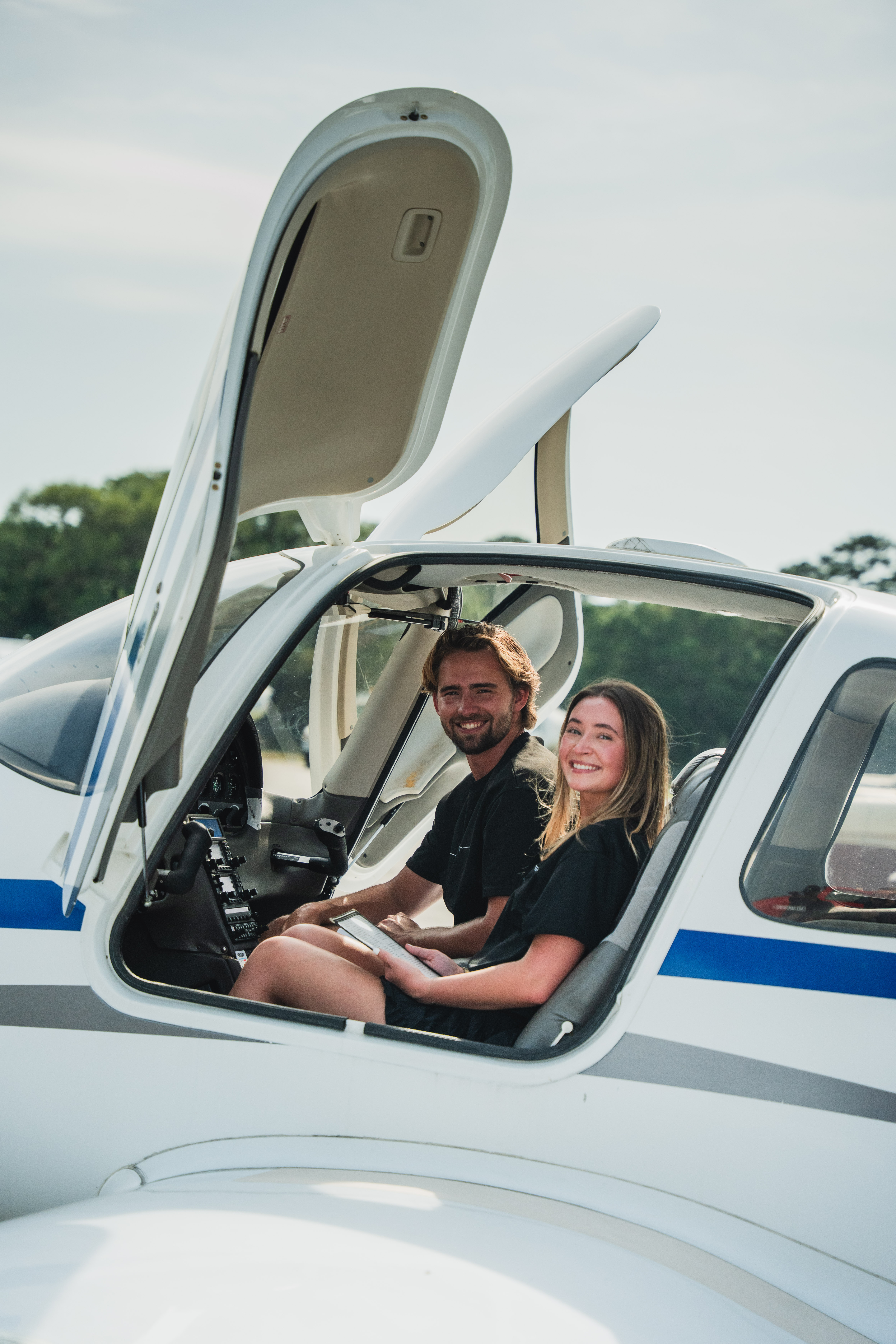 Close-up of hands typing on a laptop keyboard on a wooden desk, with the screen turned off.