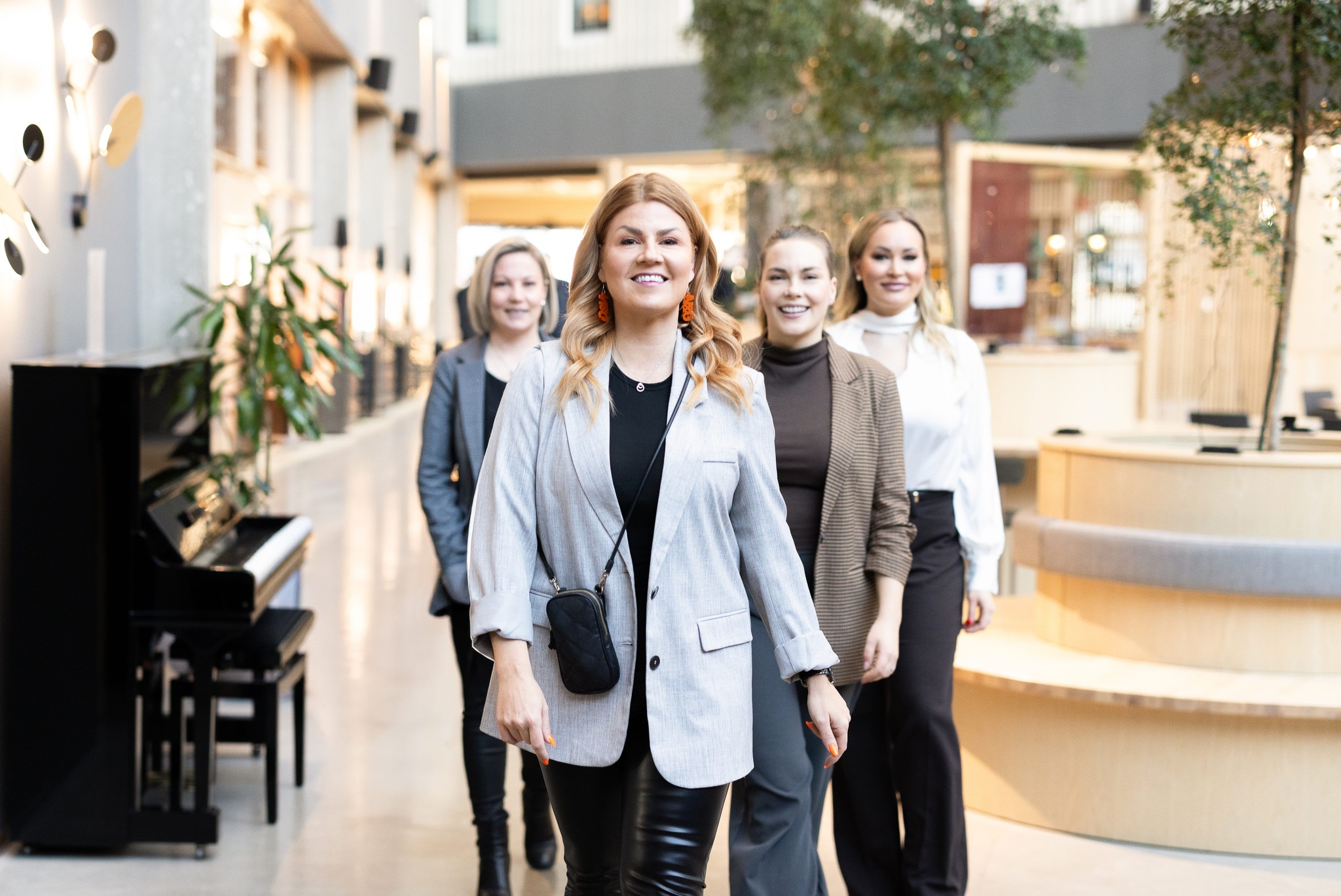 Network & Growthin valmentajatiimi kävelee yhdessä modernissa toimistotilassa.