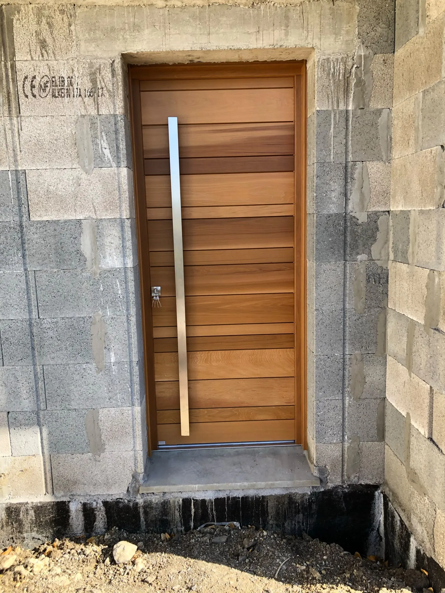 Porte d’entrée aspect bois dans une façade en pierre — AFermetures