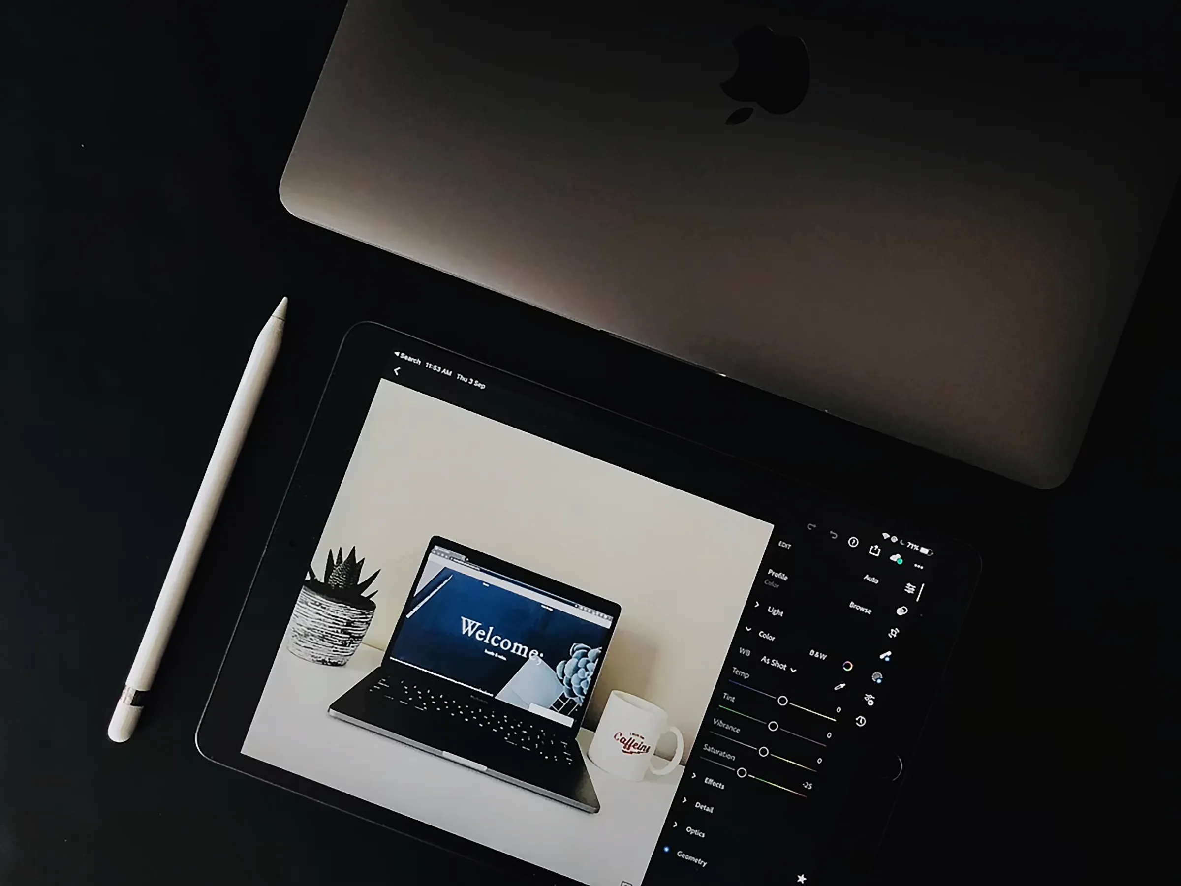 An iPad screen displays a laptop on a dark background.
