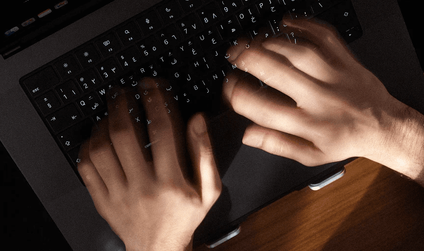 A top-down shot of hands typing on keyboard