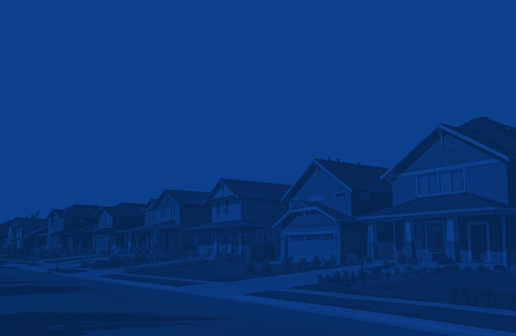 A row of houses lined up along a street, set against a clear blue sky.