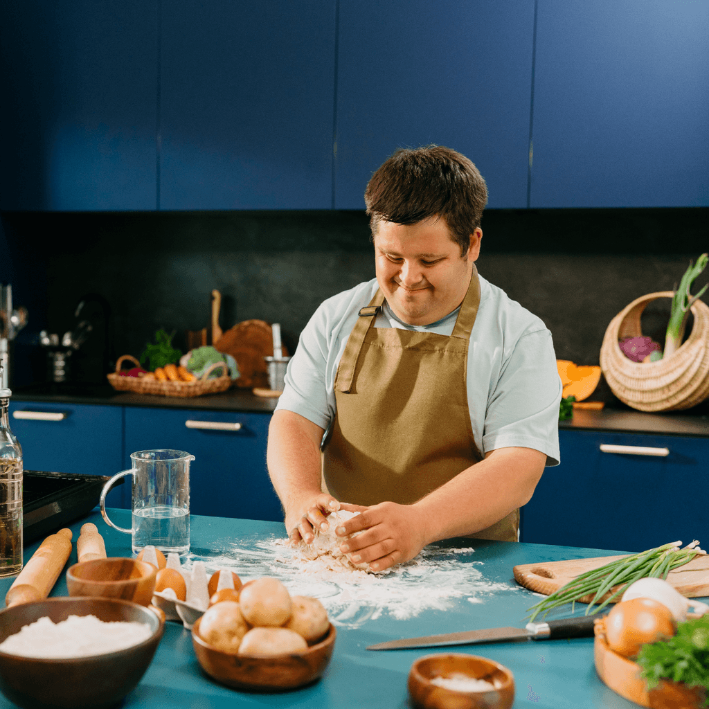 A person with Down syndrome attending a cooking class and creating a loaf of bread