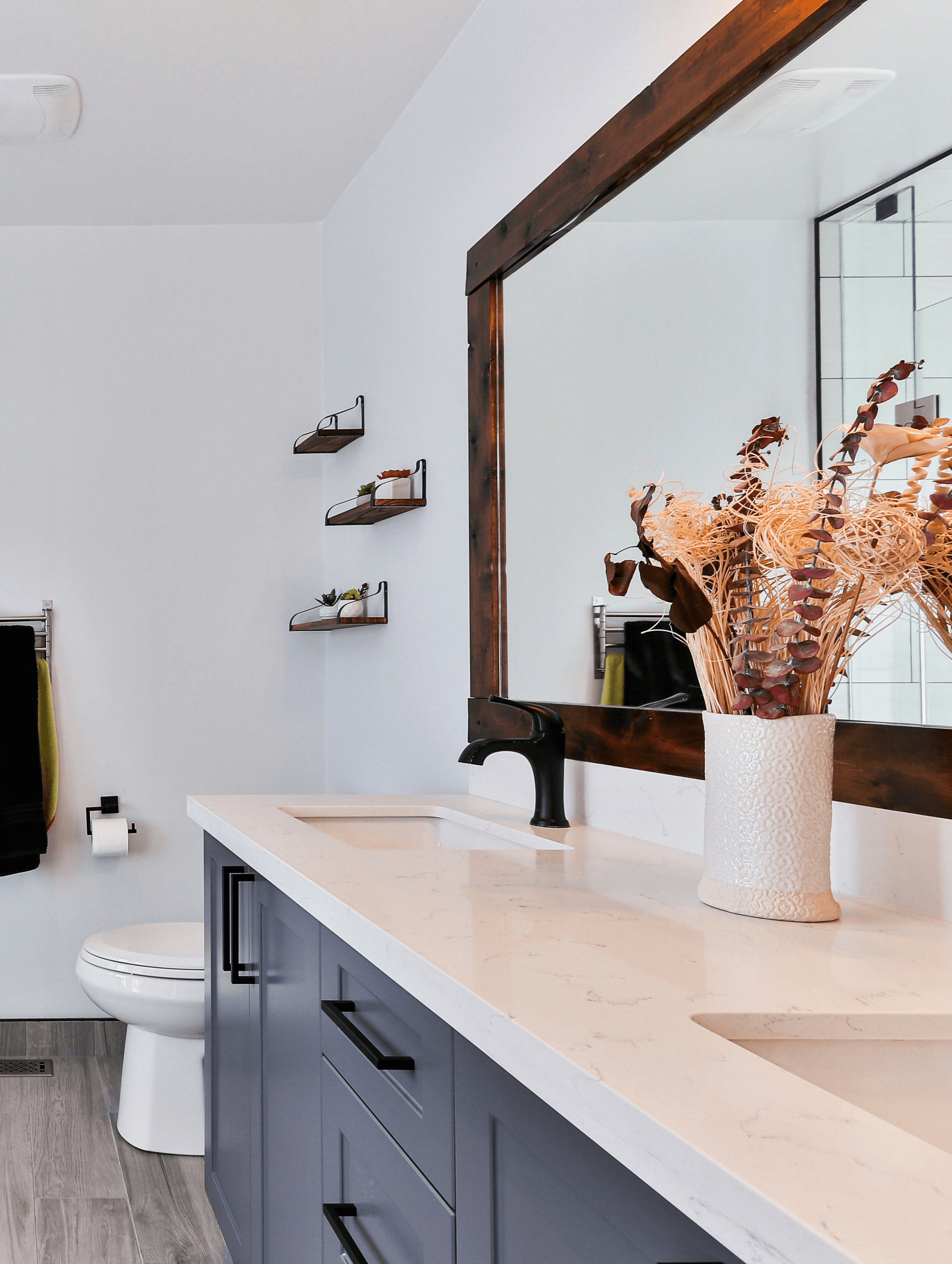 Modernes Badezimmer mit Doppelwaschbecken und stilvollem Holzrahmenspiegel – Aqua-Fix Sanitär plant und realisiert ästhetische Badezimmerlösungen für Haushalte in Wil, St. Gallen und Umgebung.