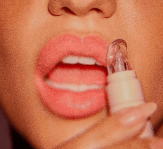 Glossy lips with clear lip balm applicator closeup