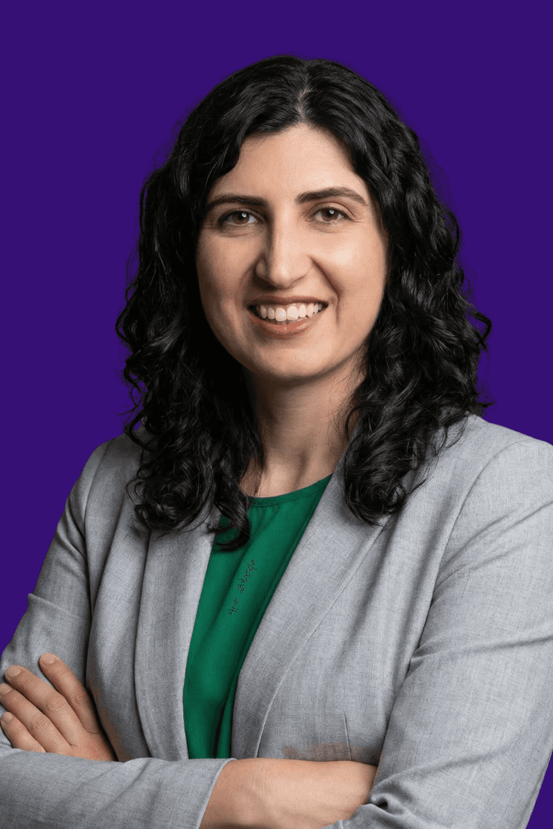 Portrait of a person in a pink sweater against a light background