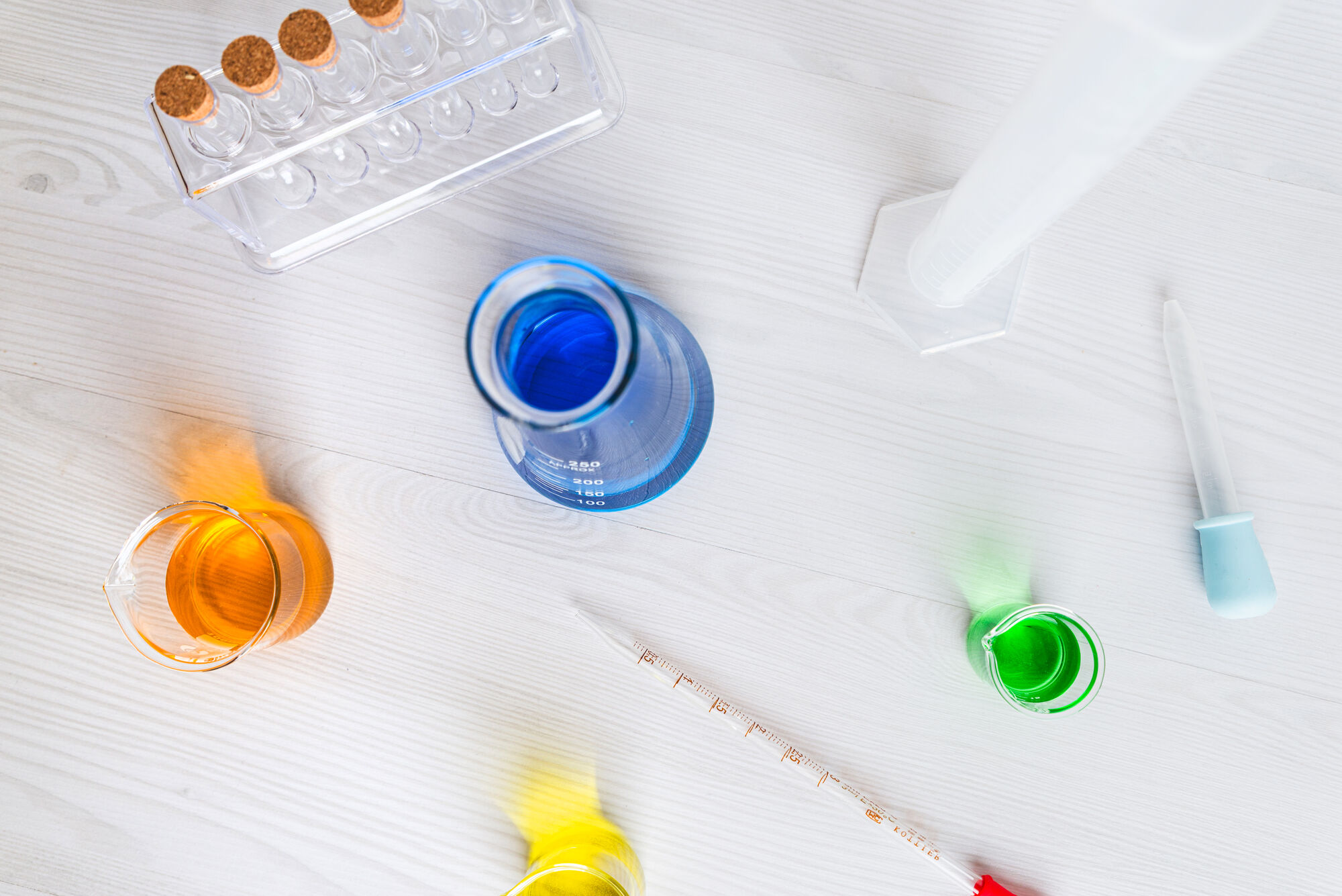 Silhouette of a researcher examining a slide under a microscope with a blue background.
