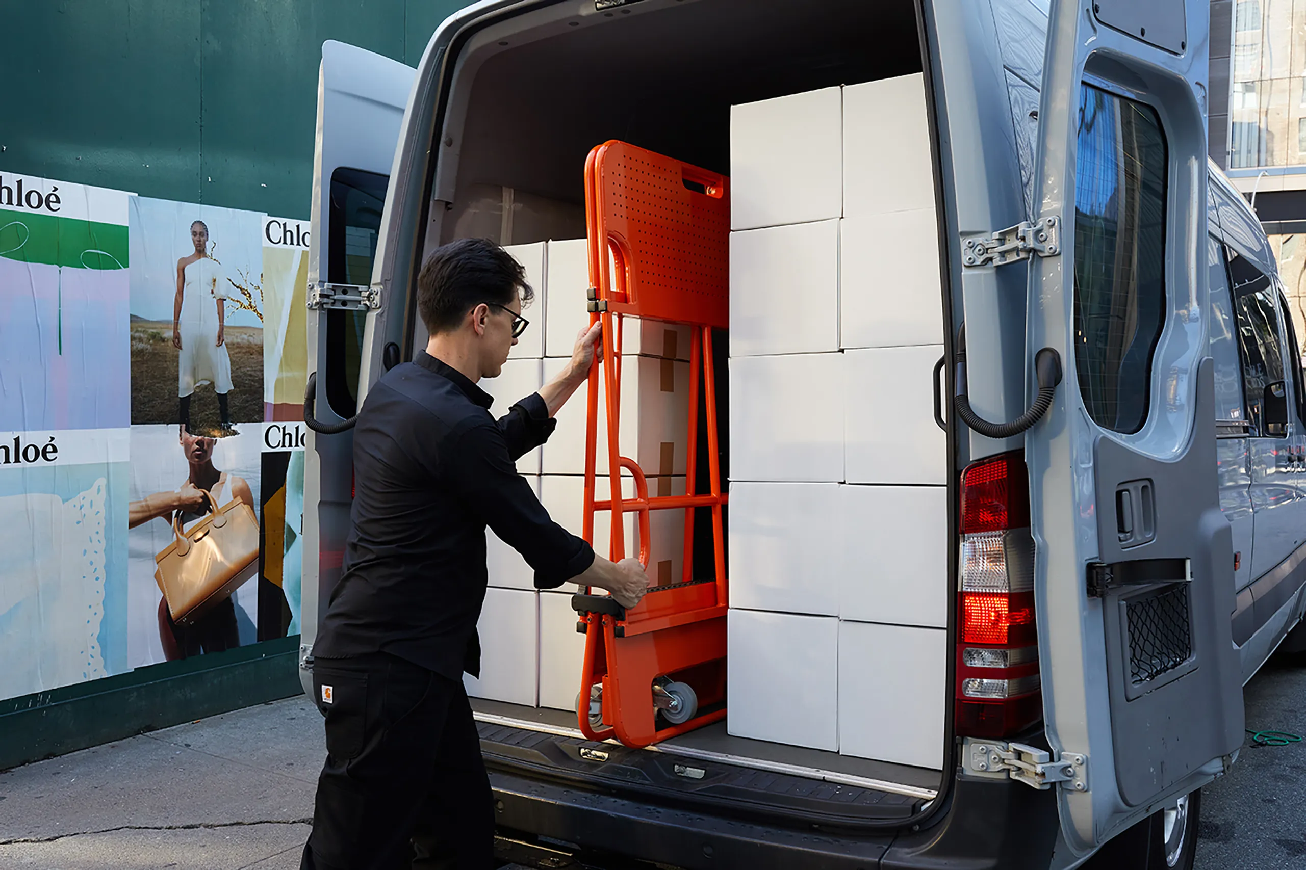 Person loading the folded Butterfly Cart into the rear of a work van
