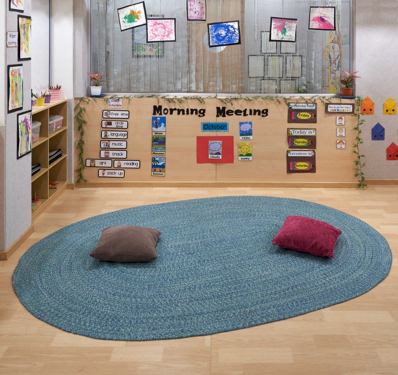 Nature-inspired preschool entrance with sculptural tree partitions and suspended green leaf ceiling panels.