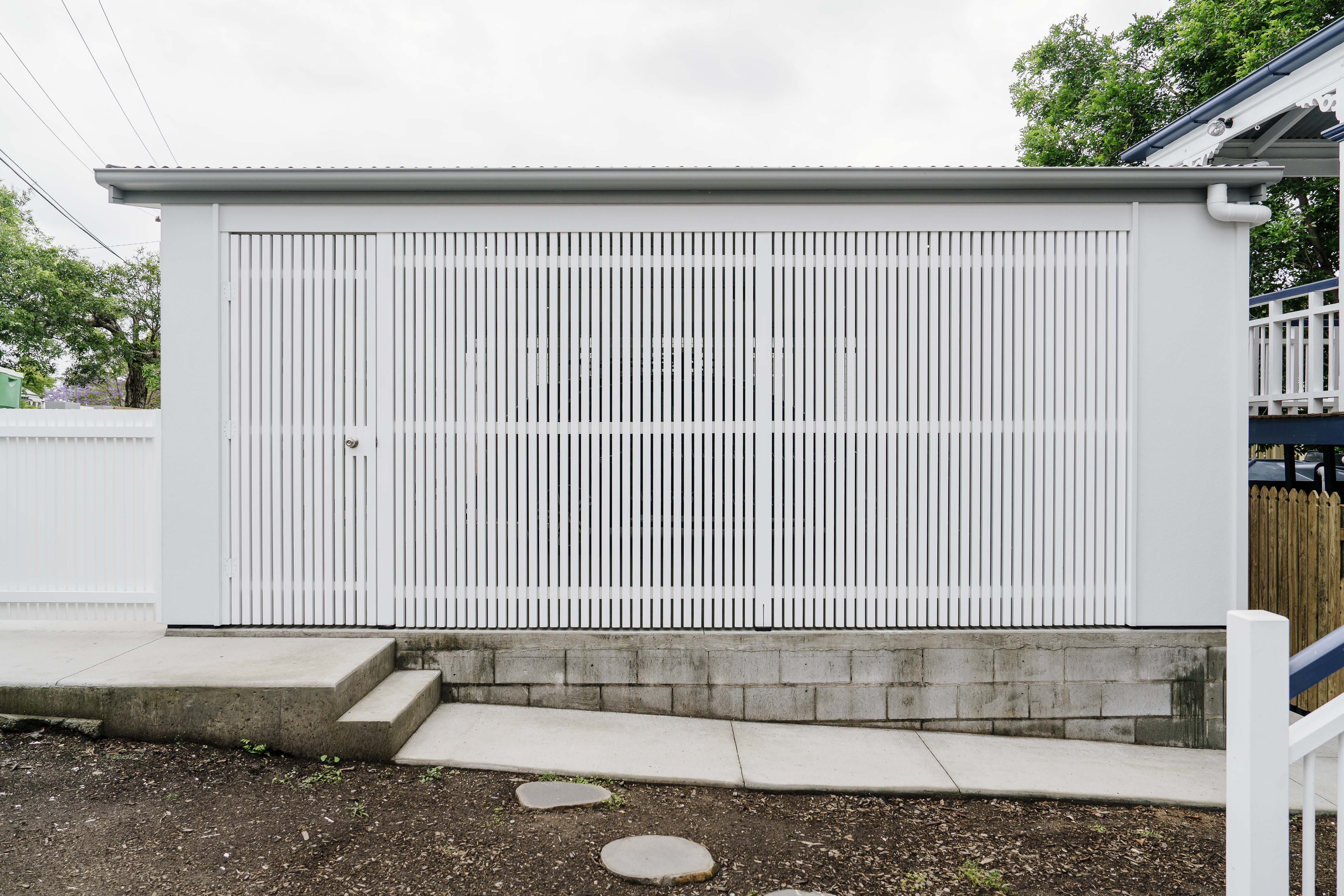 New white battened carport built beside a heritage-listed timber house