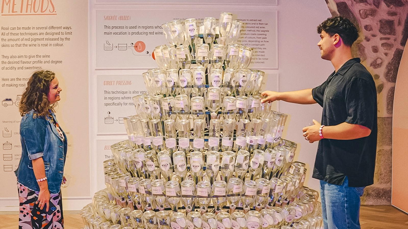 Látogatók fedezik fel a borosüveg-kijelzőt a Rózsaszín Palotában.