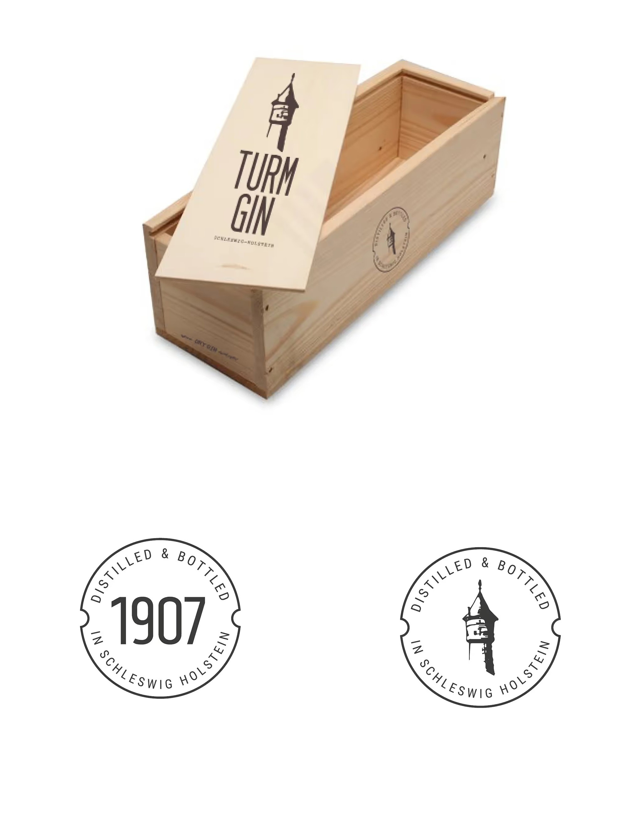 Offene Holzkiste mit aufgestelltem Deckel, auf dem ein stilisierter Turm und der Schriftzug 'TURM GIN' zu sehen sind, darunter zwei runde schwarz-weiße Siegel mit den Texten 'DISTILLED & BOTTLED IN SCHLESWIG HOLSTEIN' und '1907' beziehungsweise einem Turm-Symbol