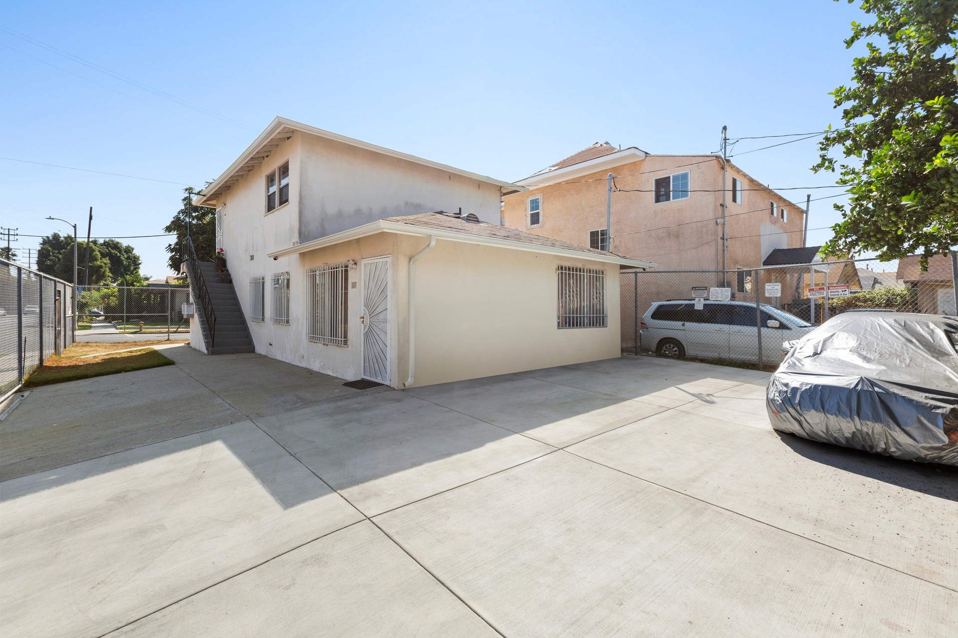 A residential building at 4421 Wall, with a driveway, featuring a garage and parked vehicles under a clear blue sky.