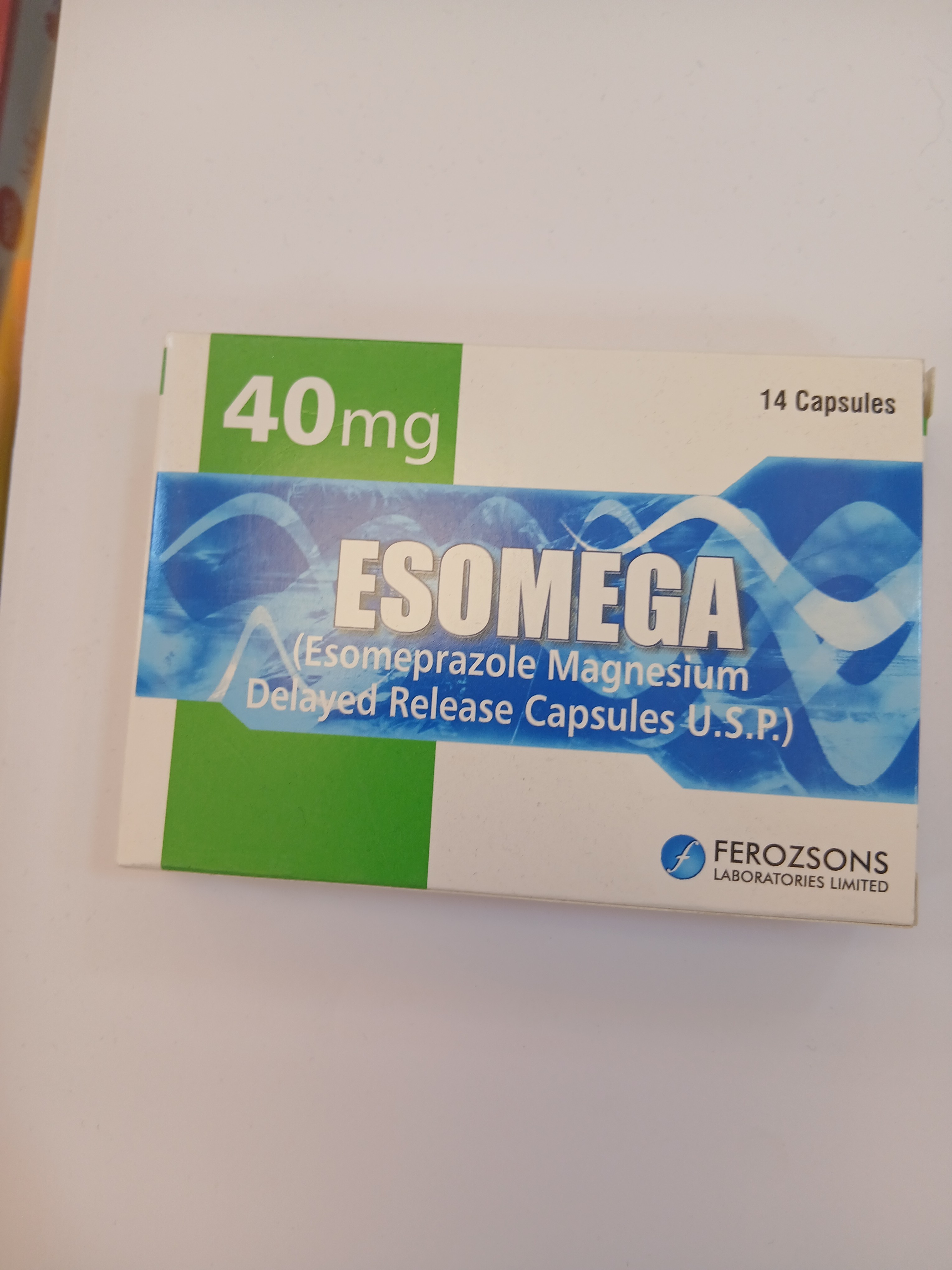 White cardboard packaging displays a green and blue label with text indicating "40mg" and "14 Capsules," featuring an illustration of capsules and a wave-like design.