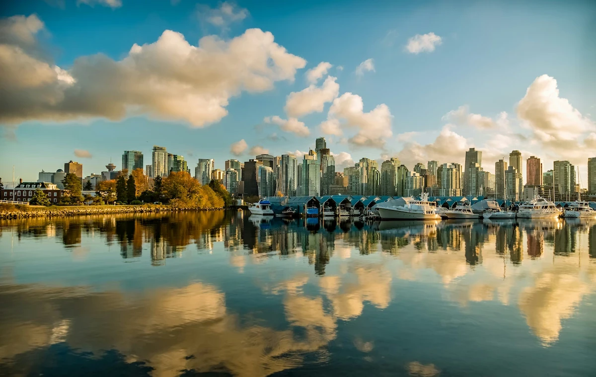 Vancouver skyline across a calm marina, Canada, with boats and city reflections in the water.